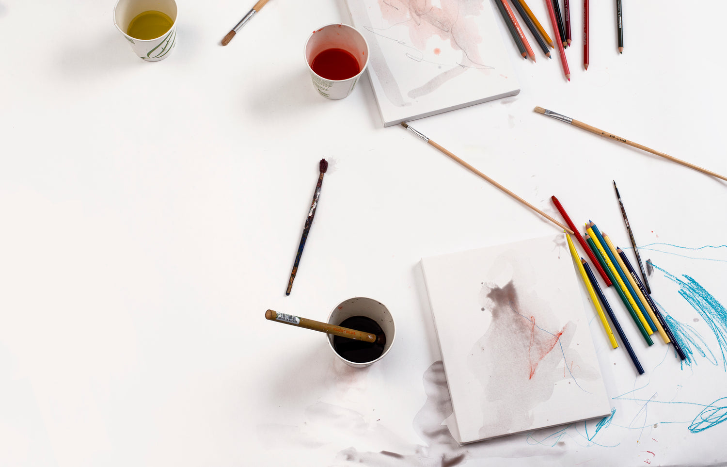 art supplies and sketchbook on white table