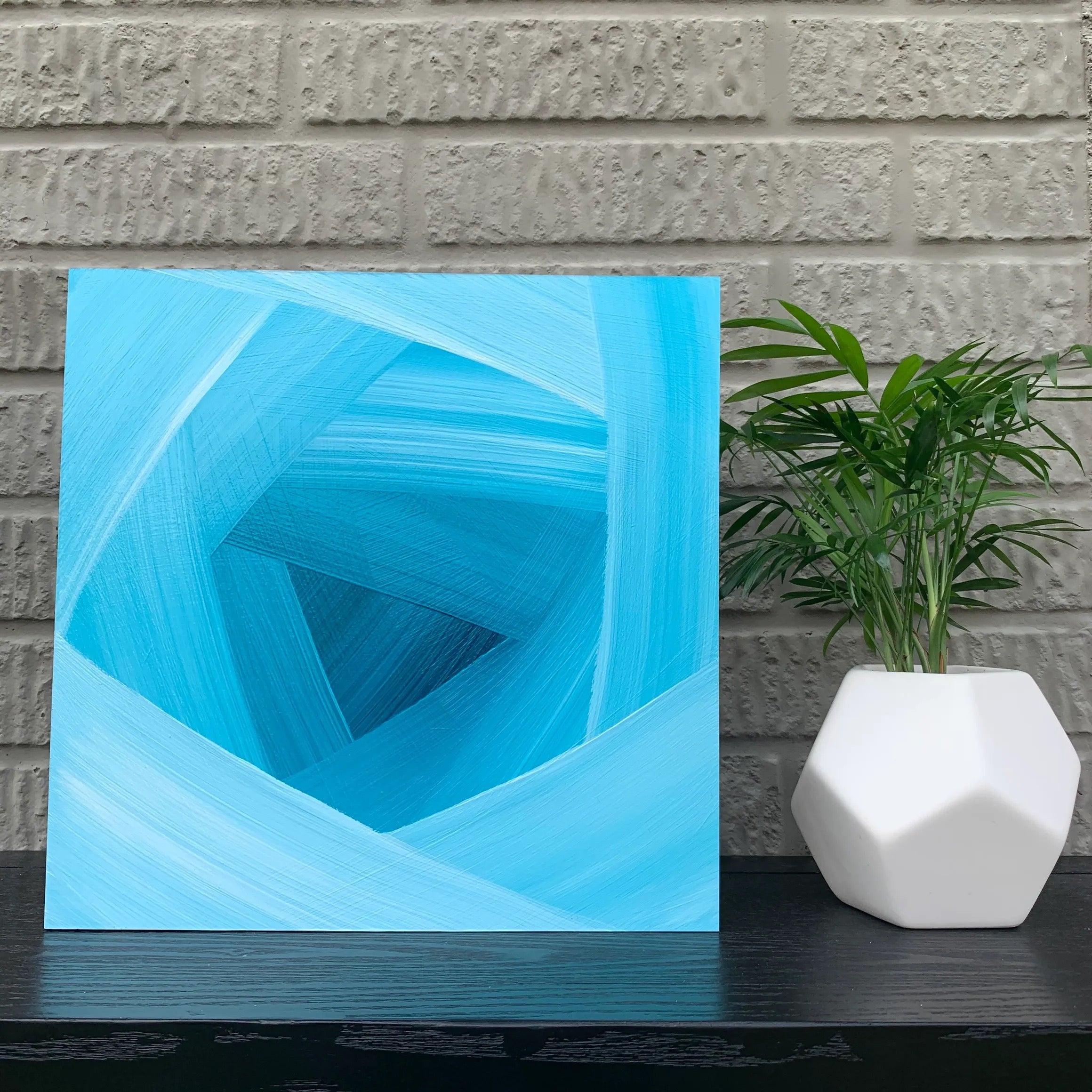 Blue geometric painting sitting on a table by Artist, Camille Gerrick
