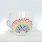 Porcelain Colorful Short Latte Mug with hand-painted dotted ROYGBIV rainbow sitting on white shelf, made by Camille Gerrick