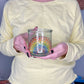 Person holding a clear glass cup with hand-painted dotted ROYGBIV rainbow by Camille Gerrick, 